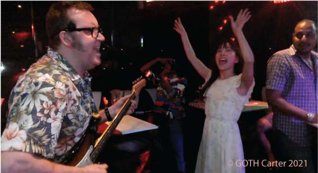 GOTH Carter live performance photo with admiring girl fan hands in the air.